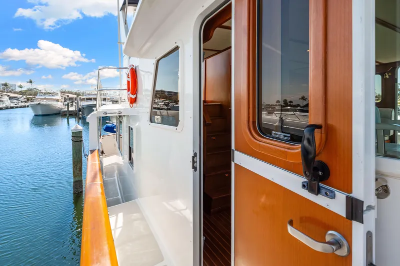 Slide: The Image of 2008 DeFever 52 Euro yacht docked, showcasing side deck and open cabin door. - 31