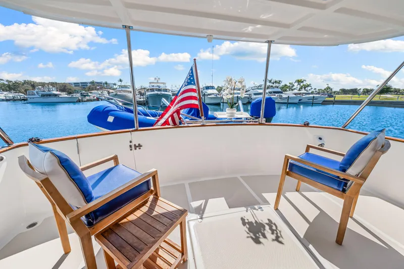 Slide: The Image of 2008 DeFever 52 Euro yacht deck with chairs, American flag, and marina view. - 33