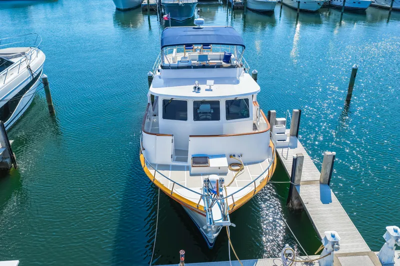 Slide: The Image of 2008 DeFever 52 Euro yacht docked in a marina, surrounded by calm blue water. - 5