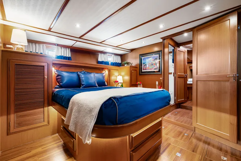 Slide: The Image of Luxurious 2008 DeFever 52 Euro yacht bedroom with elegant wood finish and blue bedding. - 70