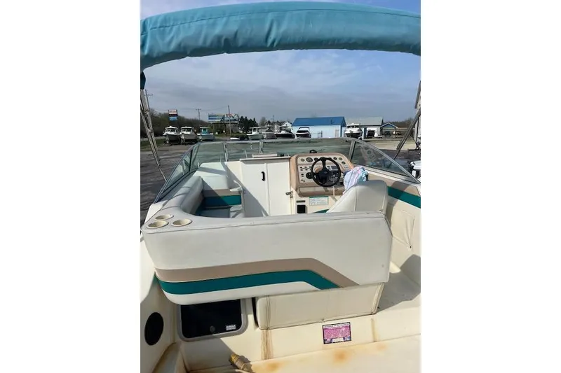 Slide: The Image of 1996 Rinker Fiesta Vee 265 boat interior with steering wheel and seating. - 10