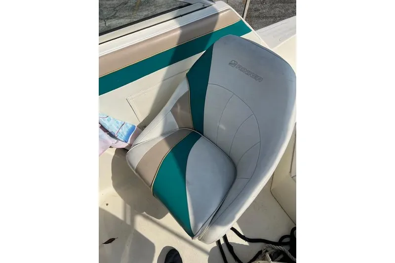 Slide: The Image of 1996 Rinker Fiesta Vee 265 boat seat with teal and beige upholstery. - 11