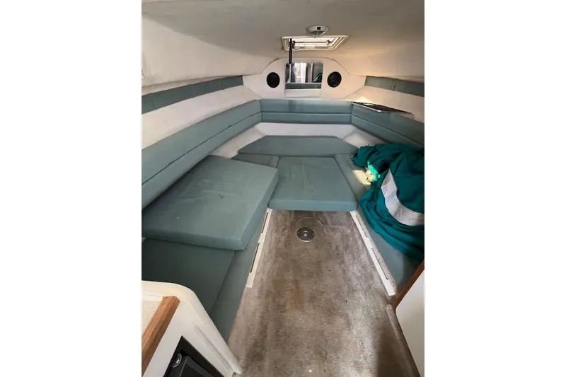 Slide: The Image of Interior cabin of 1996 Rinker Fiesta Vee 265 with teal seating and carpet flooring. - 3