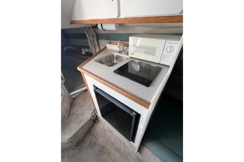 Slide: The Image of Compact kitchenette in a 1996 Rinker Fiesta Vee 265 boat with sink and microwave. - 4