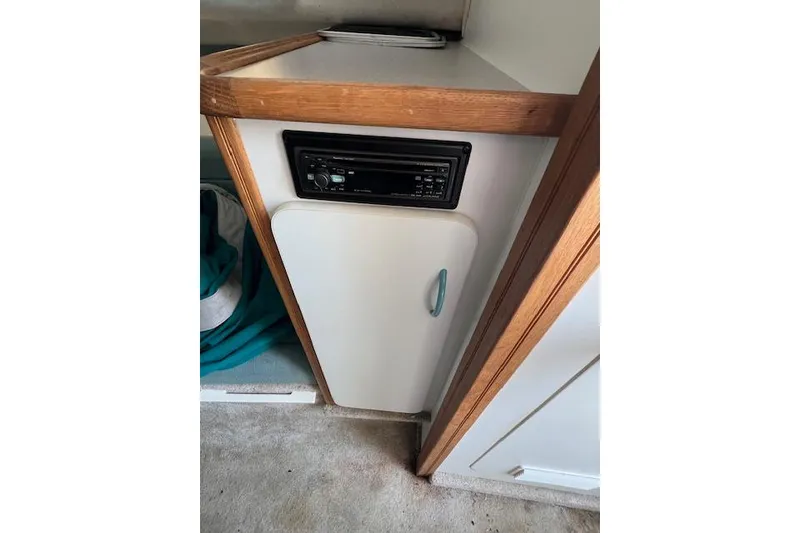 Slide: The Image of 1996 Rinker Fiesta Vee 265 cabin interior with stereo and storage cabinet. - 5