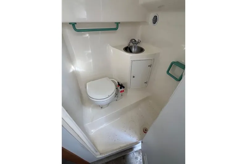 Slide: The Image of Compact bathroom in 1996 Rinker Fiesta Vee 265 boat with toilet and sink. - 6