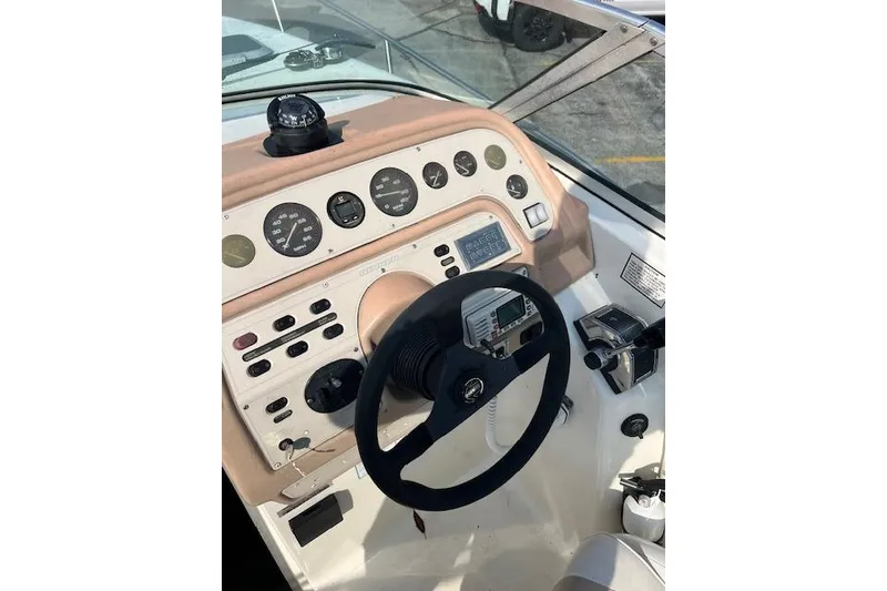 Slide: The Image of 1996 Rinker Fiesta Vee 265 boat dashboard with steering wheel and instrument panel. - 8