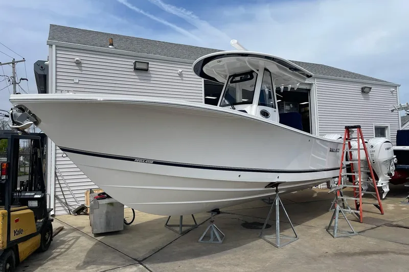 Slide: The Image of 2024 Regulator 28 Forward Seating boat on stands outside a building. - 10