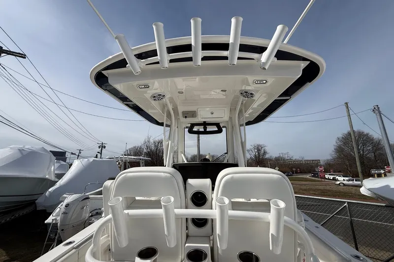 Slide: The Image of 2024 Regulator 28 Forward Seating boat with rod holders and T-top, viewed from the rear. - 23