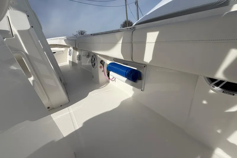 Slide: The Image of 2024 Regulator 28 Forward Seating boat interior with white upholstery and blue hose. - 25