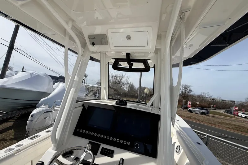 Slide: The Image of 2024 Regulator 28 Forward Seating boat dashboard with modern controls and steering wheel. - 26
