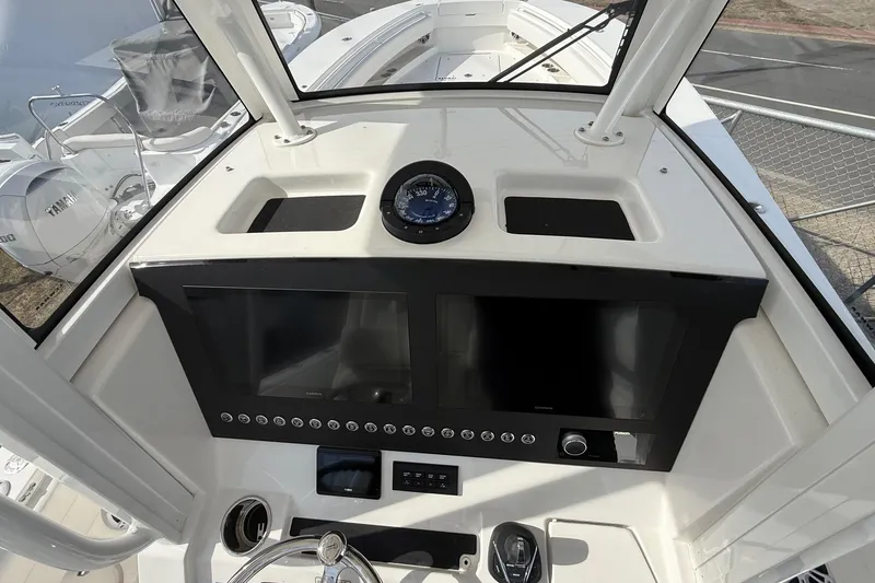 Slide: The Image of 2024 Regulator 28 Forward Seating boat dashboard with navigation controls and compass. - 27