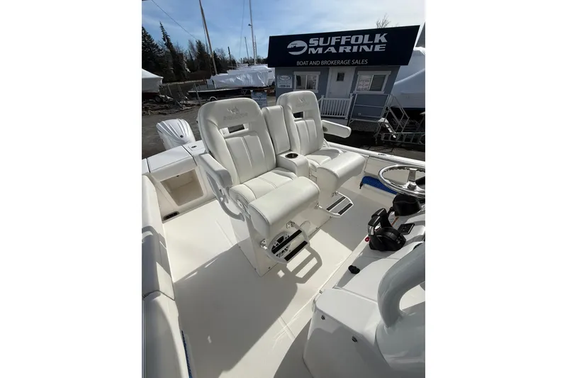 Slide: The Image of 2024 Regulator 28 Forward Seating boat interior with white captain chairs and control panel. - 35