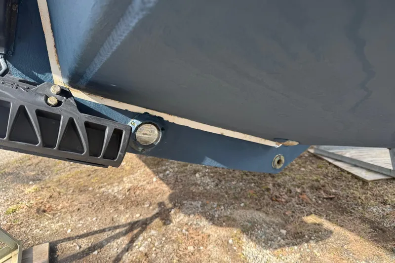 Slide: The Image of 2024 Regulator 28 Forward Seating boat hull detail with trim tab and drain plug. - 38