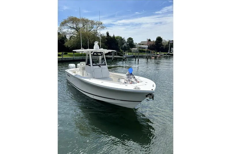 Slide: The Image of 2024 Regulator 28 Forward Seating boat on calm water, featuring sleek design and modern amenities. - 4