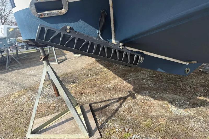 Slide: The Image of 2024 Regulator 28 Forward Seating boat hull on a stand, outdoor setting. - 9