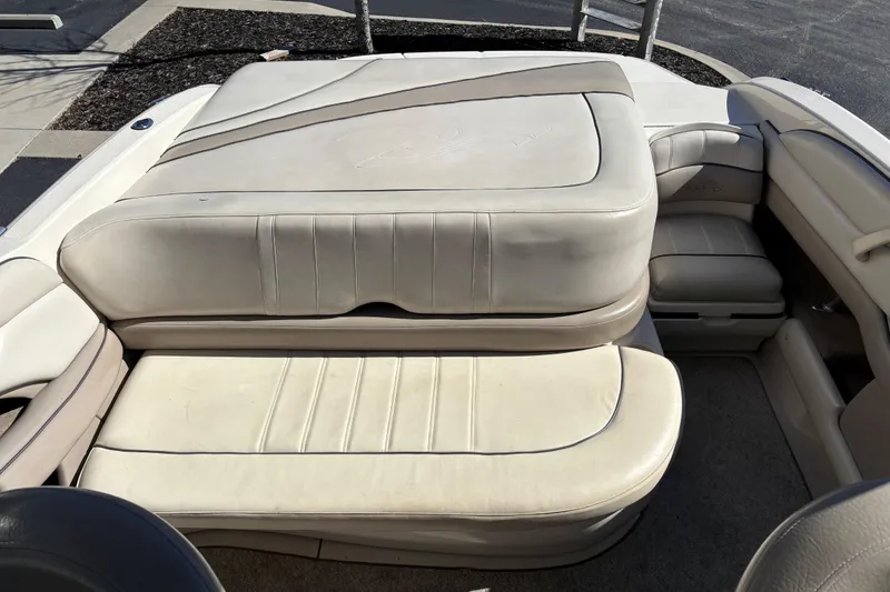Slide: The Image of 2003 Sea Ray 200 Bow Rider interior with beige leather seating and sun pad. - 12