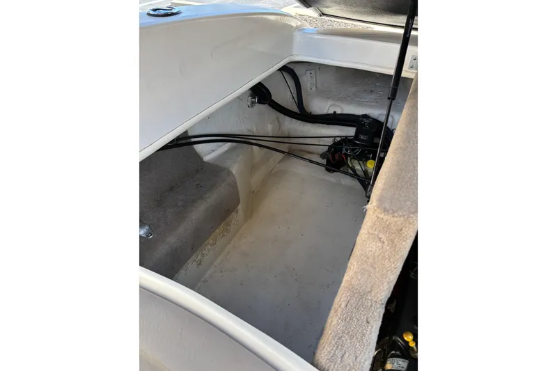 Slide: The Image of 2003 Sea Ray 200 Bow Rider storage compartment with visible wiring and components. - 13