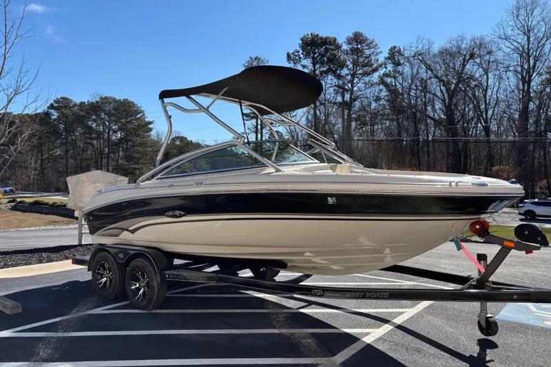 Slide: The Image of 2003 Sea Ray 200 Bow Rider boat on trailer, parked outdoors under clear sky. - 2