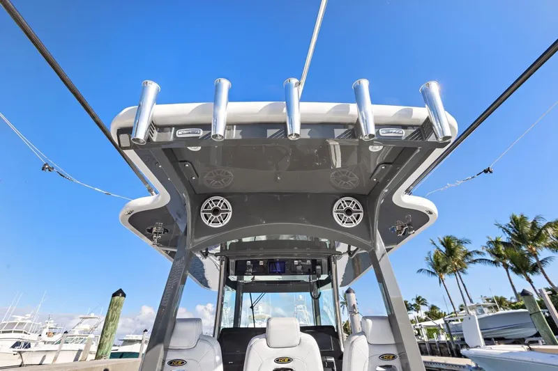 Slide: The Image of 2023 HCB 39 Speciale boat with rod holders and speakers, docked under clear blue sky. - 27