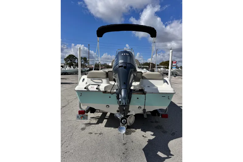 Slide: The Image of 2021 Key West 189 FS boat with outboard motor, parked outdoors under a blue sky. - 3