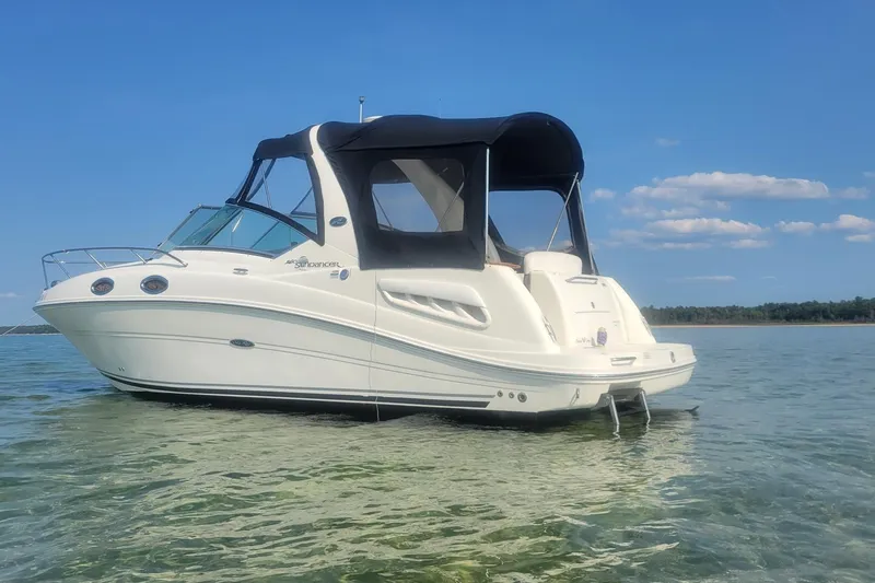 The Image of 2006 Sea Ray Sundancer 260 boat on calm water under clear blue sky. - 0