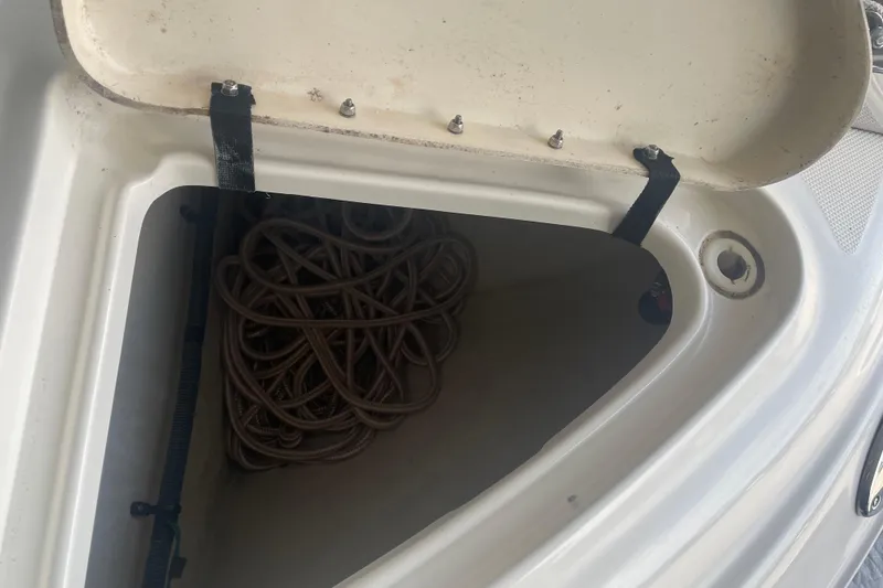 Slide: The Image of Open storage compartment on 2006 Sea Ray Sundancer 260 boat with coiled rope inside. - 16