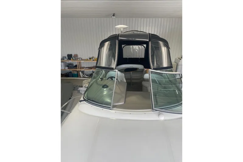 Slide: The Image of 2006 Sea Ray Sundancer 260 boat in storage, featuring a sleek design and covered cockpit. - 17