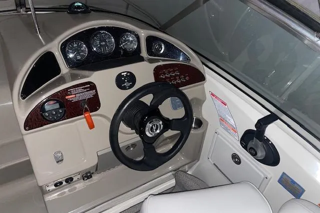 Slide: The Image of 2006 Sea Ray Sundancer 260 helm with steering wheel, gauges, and controls. - 6