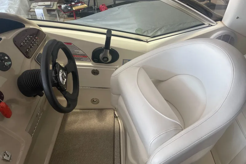Slide: The Image of Interior helm of 2006 Sea Ray Sundancer 260 with steering wheel and white captain's chair. - 7