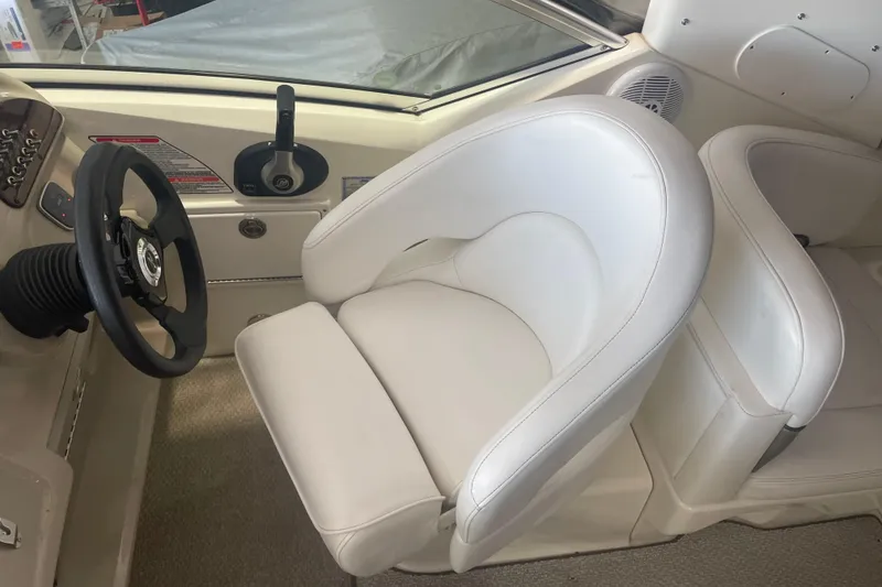 Slide: The Image of 2006 Sea Ray Sundancer 260 helm with white captain's chair and steering wheel. - 8