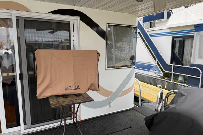 Slide: The Image of Houseboat deck with covered furniture, featuring a 2001 Sharpe 80 X 18 model. - 105