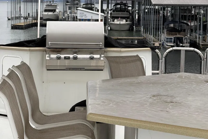 Slide: The Image of Outdoor dining area on 2001 Sharpe 80 X 18 houseboat with grill and chairs at marina. - 118