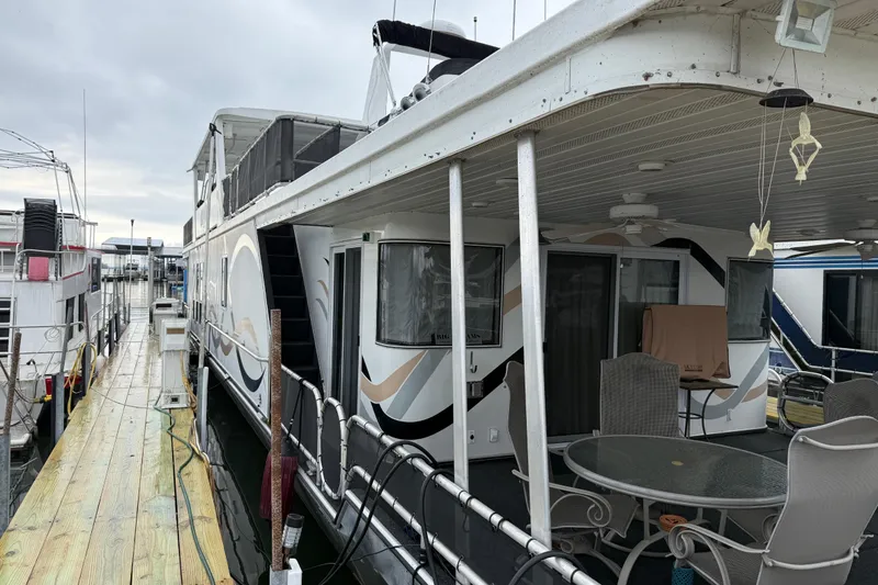 Slide: The Image of Houseboat docked at marina, Sharpe 80 X 18 model, 2001, with outdoor seating area. - 12