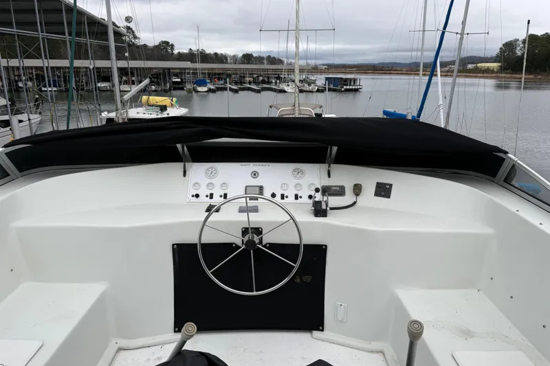 Slide: The Image of Helm of 2001 Sharpe 80 X 18 houseboat at marina, featuring steering wheel and controls. - 133