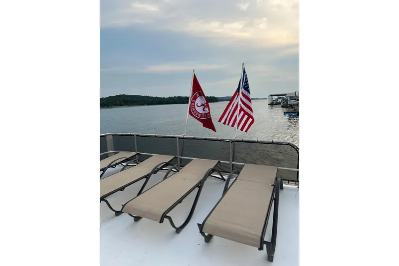 Slide: The Image of Sun loungers on 2001 Sharpe 80 X 18 houseboat deck with flags, overlooking serene lake. - 136
