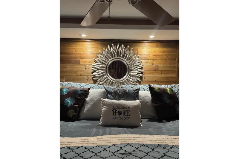 Slide: The Image of Luxurious bedroom with decorative pillows, sunburst mirror, and wooden accent wall in a Sharpe 80 X 18. - 137