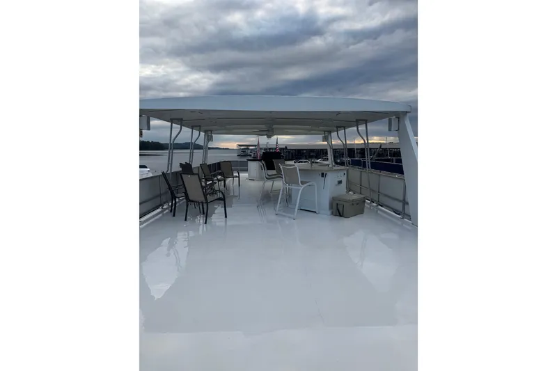 Slide: The Image of Upper deck of 2001 Sharpe 80 X 18 houseboat with chairs and overcast sky. - 140
