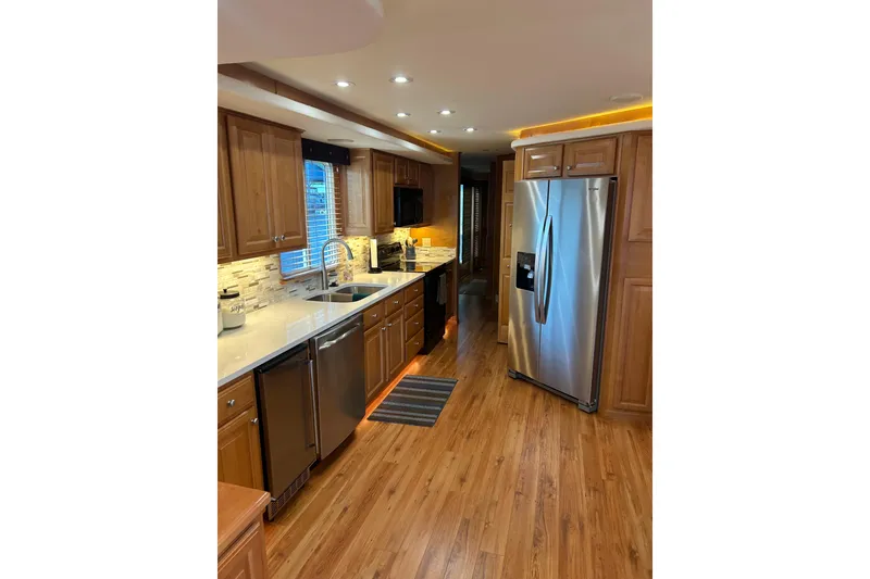 Slide: The Image of Modern kitchen with wooden cabinets, stainless steel appliances, and hardwood flooring in a 2001 Sharpe 80 X 18. - 143