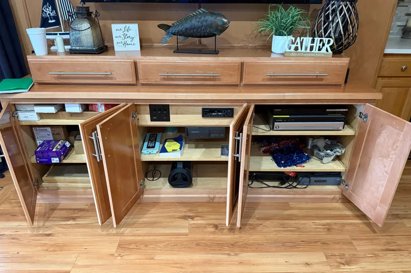 Slide: The Image of Wooden cabinet with open doors, displaying electronics and decor, on a hardwood floor. - 22