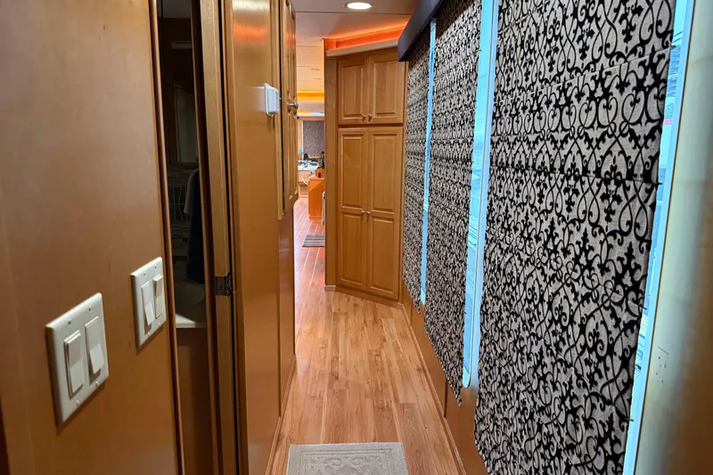 Slide: The Image of Narrow hallway in 2001 Sharpe 80 X 18 houseboat with patterned curtains and wooden flooring. - 23