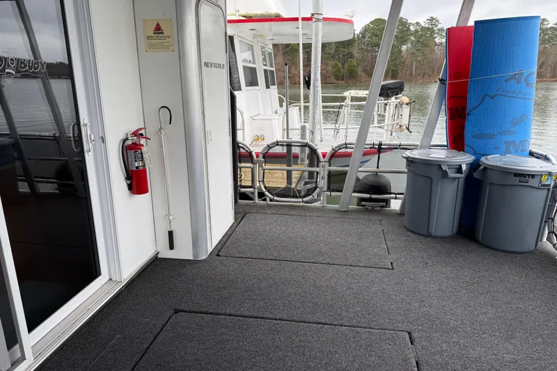 Slide: The Image of Houseboat deck with fire extinguisher, trash bins, and lake view; Sharpe 80 X 18, 2001 model. - 33