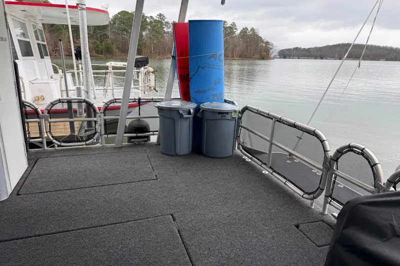 Slide: The Image of Houseboat deck with trash bins and yoga mat, Sharpe 80 X 18, 2001 model, on a serene lake. - 34