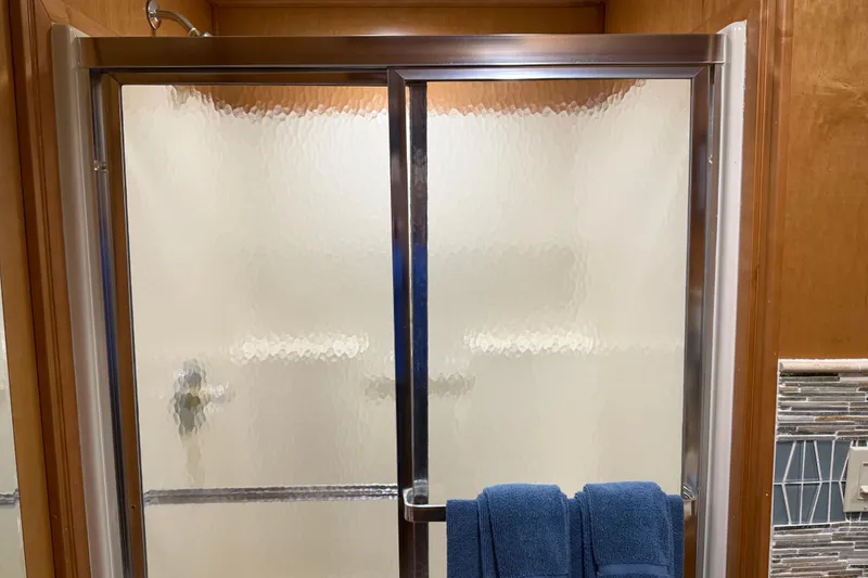 Slide: The Image of Frosted glass shower door with blue towels, wooden and tiled bathroom, Sharpe 80 X 18, 2001. - 58