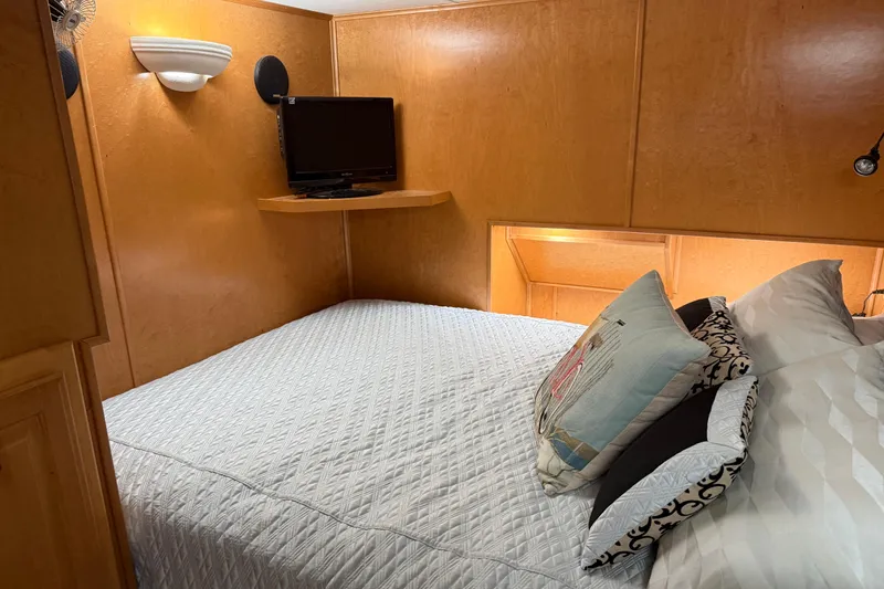 Slide: The Image of Cozy bedroom in 2001 Sharpe 80 X 18 houseboat with TV and decorative pillows. - 77