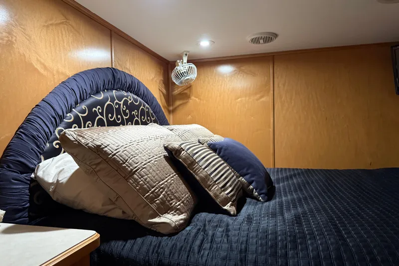 Slide: The Image of Luxurious bedroom interior in 2001 Sharpe 80 X 18 houseboat with elegant bedding and wood paneling. - 80