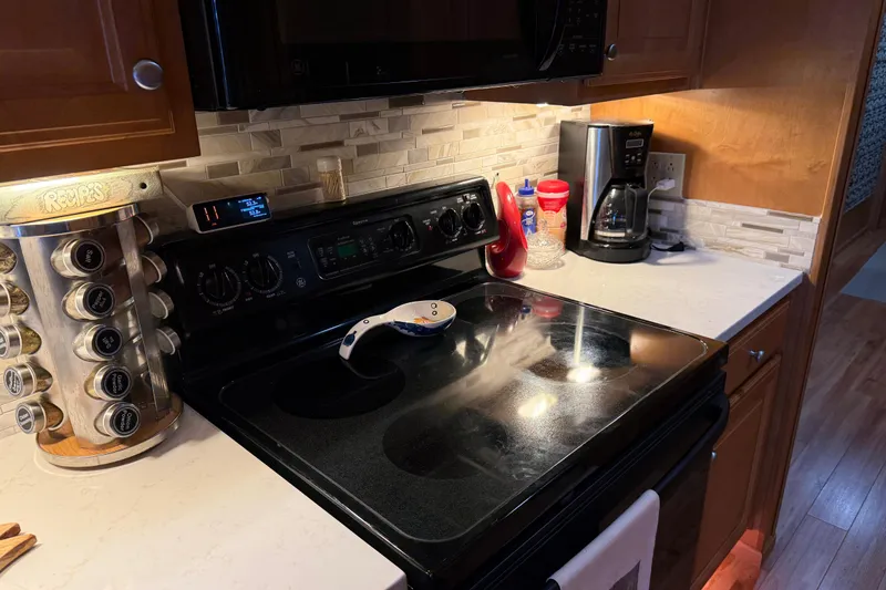 Slide: The Image of Modern kitchen with black stove, spice rack, and coffee maker on a white countertop. - 84