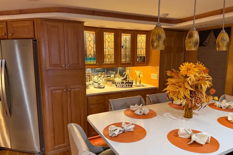 Slide: The Image of Luxurious kitchen interior with autumn decor, featuring wooden cabinets and modern lighting in a 2001 Sharpe model. - 93