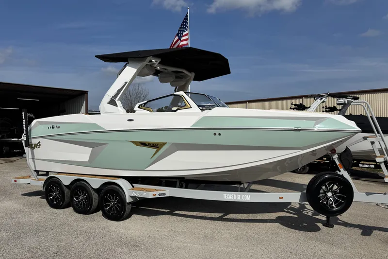 The Image of 2026 Tigé 24RZX boat on trailer, featuring sleek design and American flag. - 1