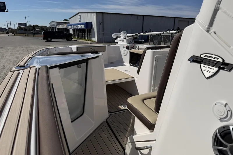 Slide: The Image of 2024 Yamaha Boats 252 FSH Sport interior with seating and marine service center background. - 7